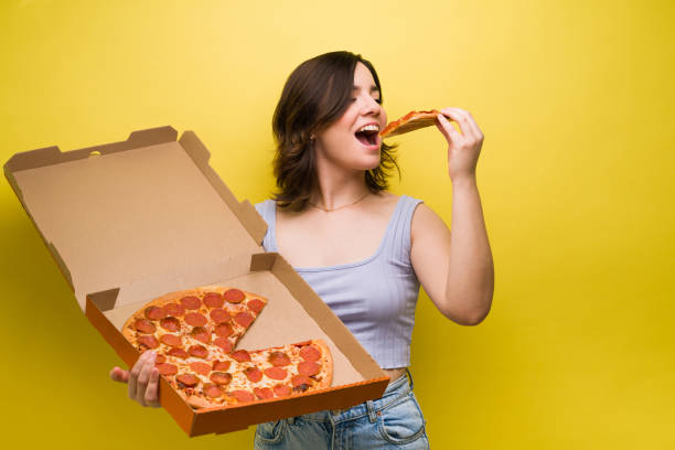 istock Hungry woman enjoying pizza 1357557235
