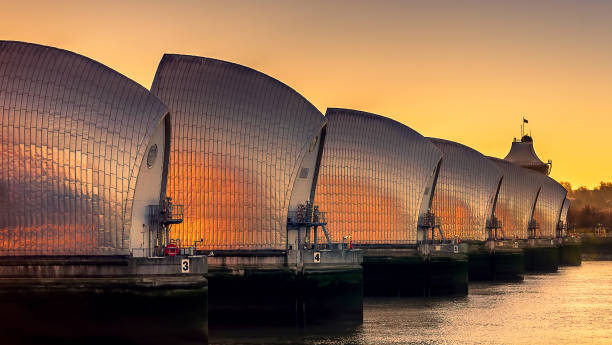 barrage de thames barrier au lever du soleil - thames flood barrier photos et images de collection