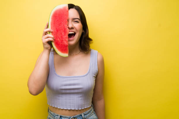 istock Cheerful woman laughing and enjoying fruit 1357558633