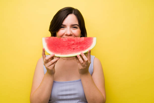 istock Beautiful woman playing with a watermelon 1357558882