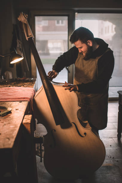 jóvenes luthiers concentrados en el trabajo en su taller - fabricante de instrumentos fotografías e imágenes de stock