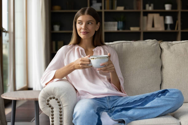 istock Happy beautiful relaxed young woman drinking coffee. 1357564384