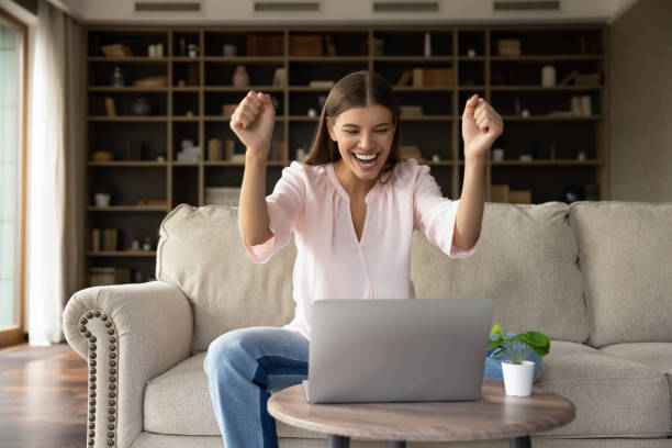 istock Euphoric young woman celebrating internet success at home. 1357564396