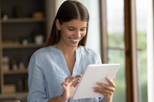 istock Happy young attractive woman using digital touchpad gadget. 1357564424