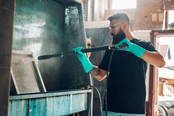 istock Male worker cleaning screen frame with water in a printing workshop 1357569821