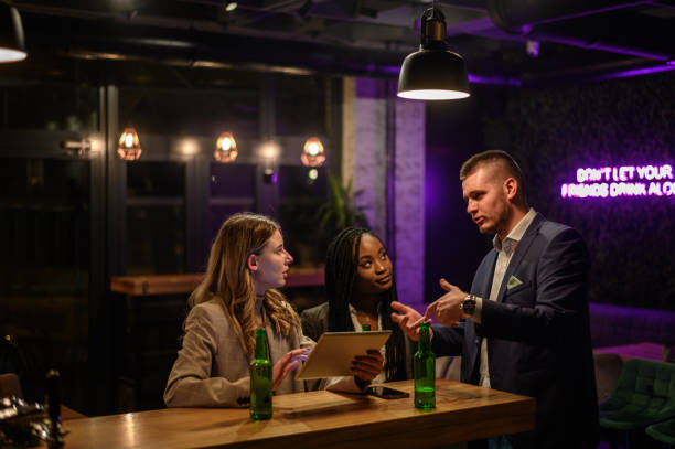 istock Cheerful colleagues drinking beer in the bar together after work 1357569843