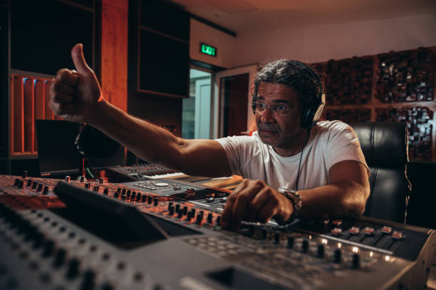 istock Senior hispanic music producer working on a mixing soundboard while in his studio 1357569901