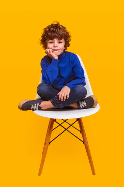 istock Stylish boy sitting on chair 1357570156