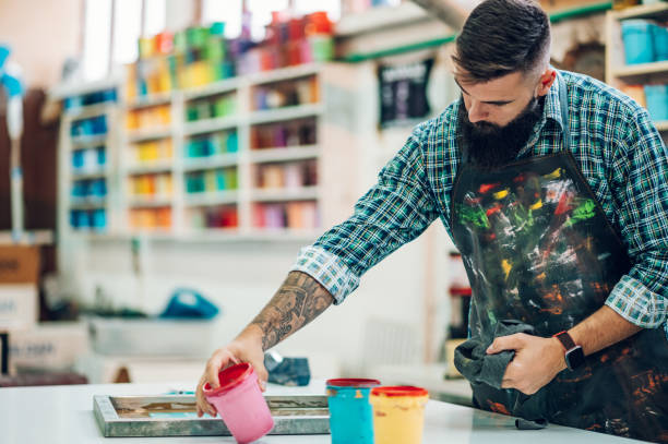 istock Male worker mixing colors for screen printing in a workshop 1357572481