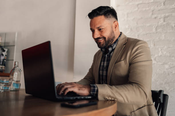 istock Businessman working on his laptop while drinking coffee in a cafe 1357572503