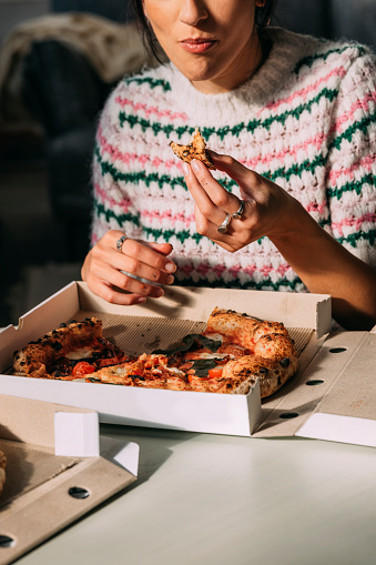 An anonymous female having pizza for lunch.