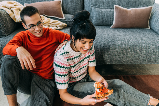 A beautiful female eating pizza her husband has made for her.