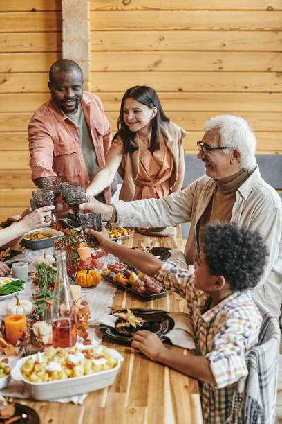 istock Cheerful family members toasting with drinks over served festive table 1357574593
