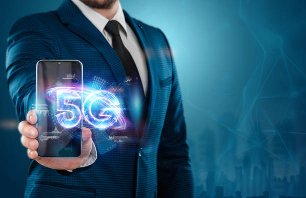 istock Smartphone glows 5G hologram, mobile technology, creative background. 5G network concept, high speed mobile internet, new generation networks. Mixed media. 1357576589