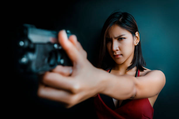 istock Woman in red aiming a gun 1357576666