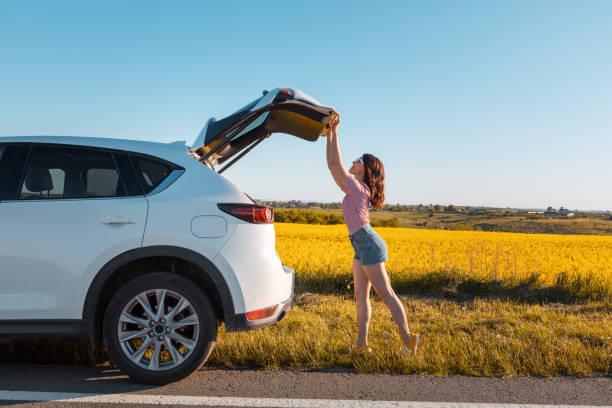 istock woman closing car trunk parked at roadside 1357577266