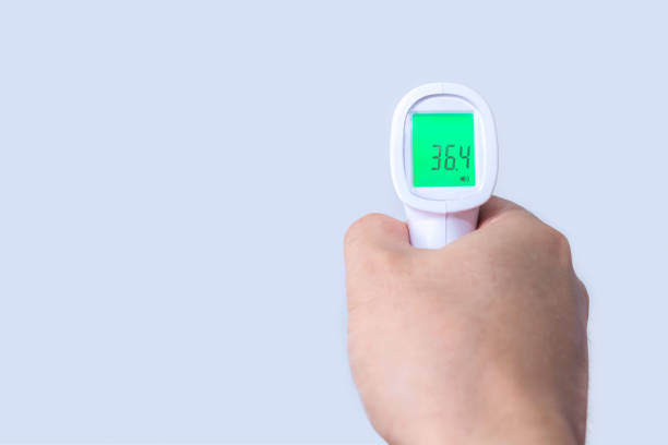 istock Hand with infrared thermometer on gray background 1357577535
