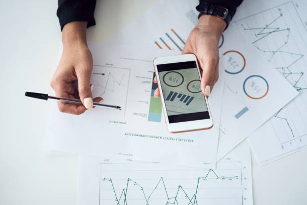 istock High angle shot of an unrecognisable businesswoman using a cellphone while going through paperwork in an office 1357577709