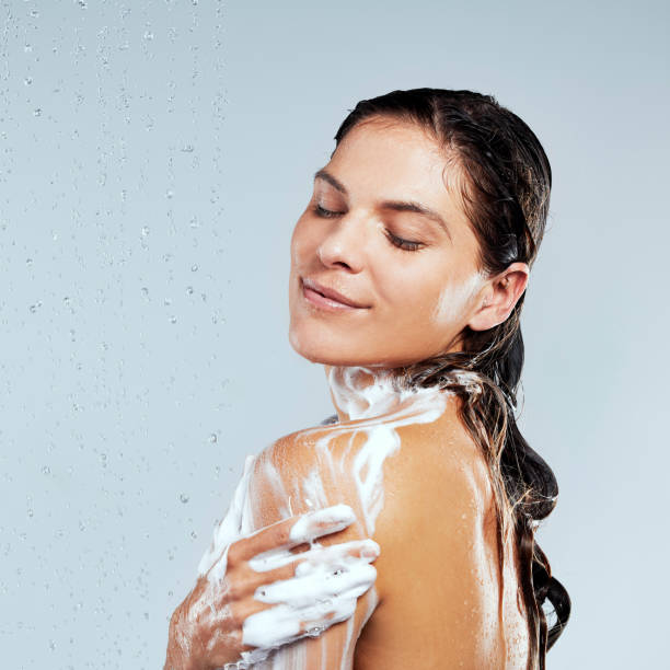 ujęcie młodej kobiety biorącej prysznic na szarym tle - shirtless caucasian freshness relaxation zdjęcia i obrazy z banku zdjęć