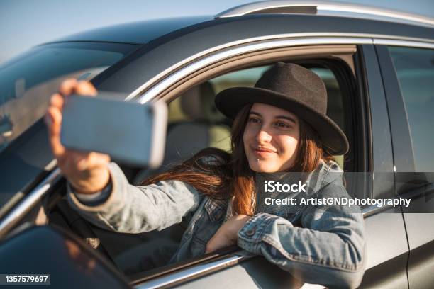 Portrait Of Smiling Woman Taking Selfie While Sitting In Car Stock Photo - Download Image Now