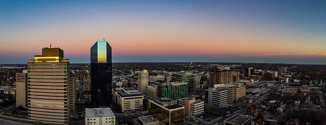 Aerial panorama of downtown Lexington, Kentucky during golden sunset. Setting sun is reflecting on tall finance office buildings.