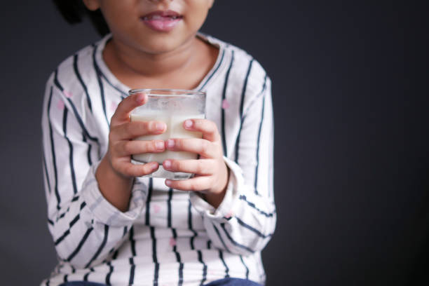 istock child girl drinking milk while sited 1357587506