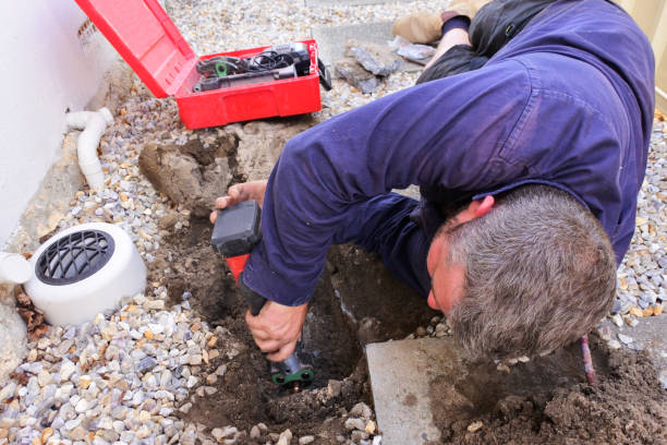Plumber fixing an underground hot water pipe leaking with a tools Above view of an Australian plumber fixing an underground hot water pipe leaking with a tools. laying underground pipes stock pictures, royalty-free photos & images