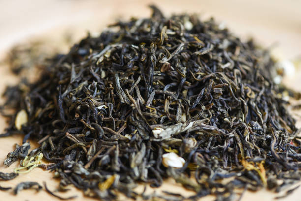 thé sec chinois sur fond bois, thé au jasmin séché pour le thé infusé, thé noir en feuilles - jasmine tea black tea tea drink photos et images de collection