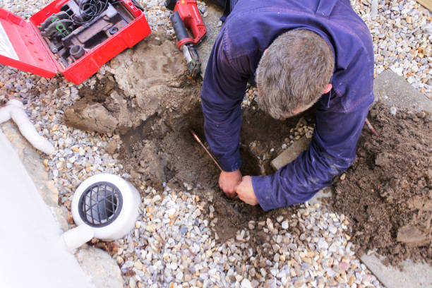 Plumber fixing an underground hot water pipe leaking with a tools Aerial view of an Australian plumber fixing an underground hot water pipe leaking with a tools. Plumber stock pictures, royalty-free photos & images