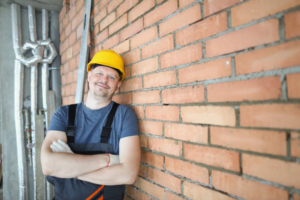 istock A man in a helmet stands against a brick wall indoors 1357595908