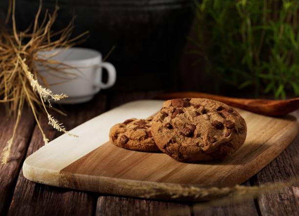 biscotti al cioccolato su tagliere di legno - cookie chocolate cake gourmet dessert foto e immagini stock