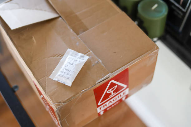 A packet of silica gel on a cardboard  delivery box  on  a table stock photo