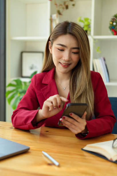 istock Businesswoman using smart mobile phone at her office desk. 1357598270