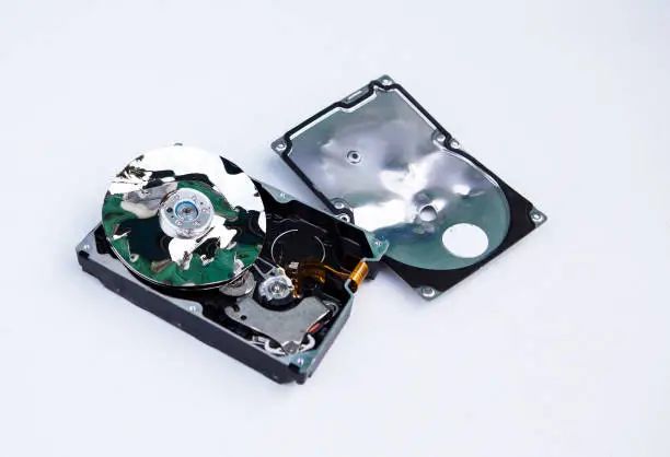 Crushed Hard Disk Drive on the White Table closeup