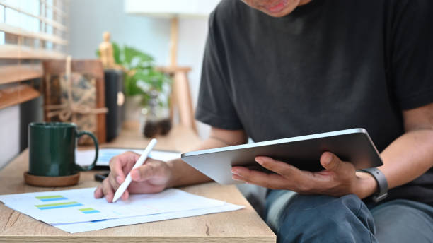 istock Cropped shot young stock trader holding digital tablet and analyzing financial graph. 1357603371