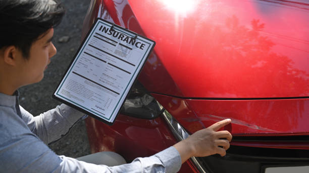 Insurance agent filling insurance claim form and inspecting damaged car after accident. Insurance agent filling insurance claim form and inspecting damaged car after accident. car insurance stock pictures, royalty-free photos & images