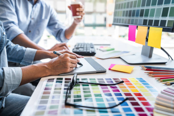 istock Young colleagues designers working together on a creative project and color samples for selection, Color swatch samples, Brainstorming Planning Partnership, creative graphic design working desktop 1357606253