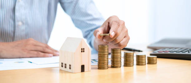istock Asian business man putting coin increase on coins stacking with house model while preparation to saving 1357606585