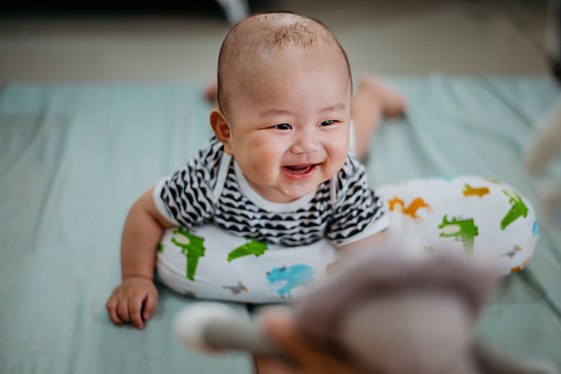 Image of an Asian Chinese baby having tummy time on mattress