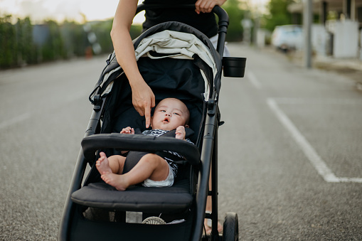Baby boy in stroller and going out for a walk with mother