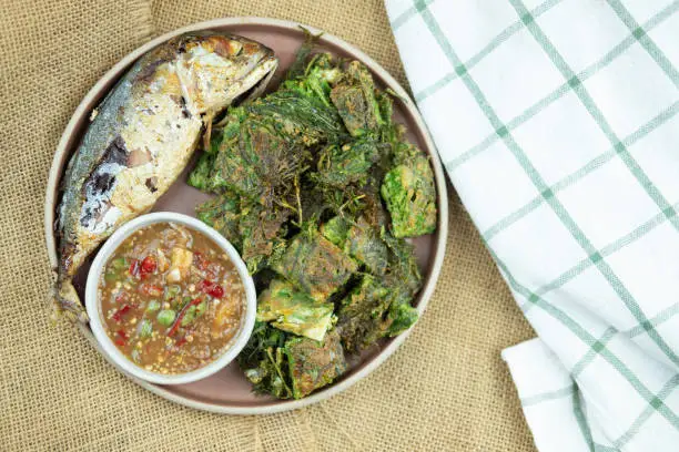 Photo of Fried mackerel with shrimp paste chilli Sauce (Nam Prik Ka Pi) served with fried Cha-OM-plated egg a popular food in Thailand