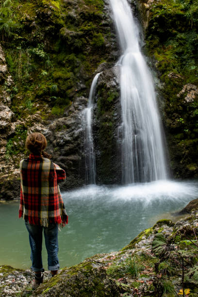 istock Mid Adult Woman Watching  Beautiful Waterfall 1357613608