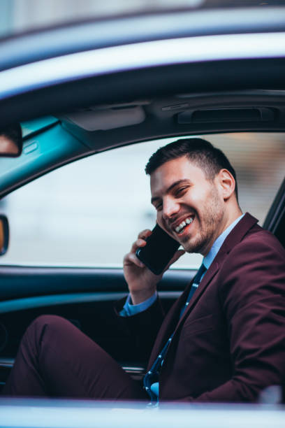 istock A manager sitting at the front seat of his limo talking on his cellphone while making a lot of hand gestures. 1357614201