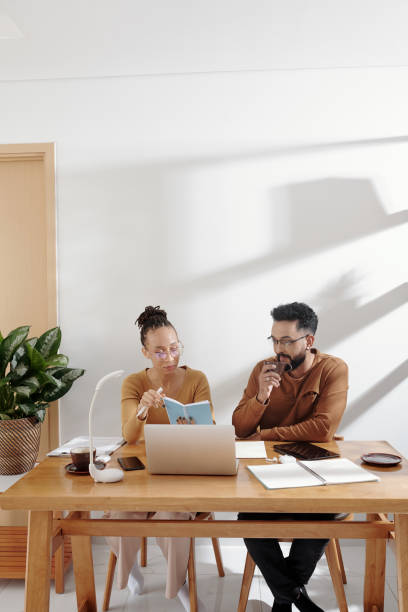 istock Business Couple Checking Plans 1357615917