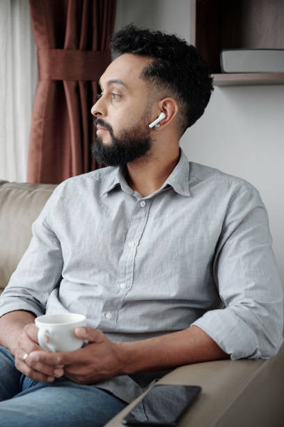 istock Pensive Man Listening to Podcast 1357615991
