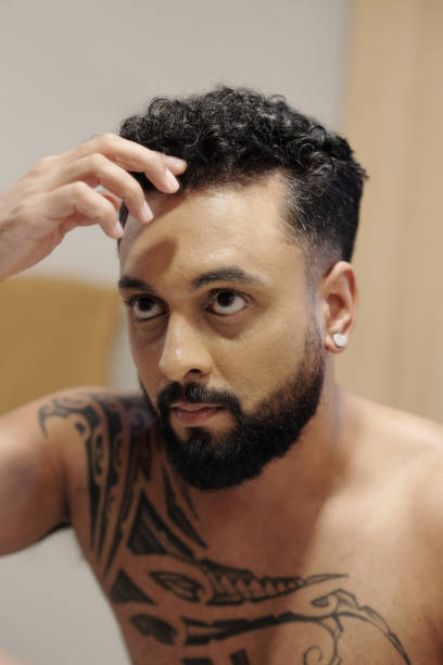 istock Man Adjusting Hair in Bathroom 1357616005