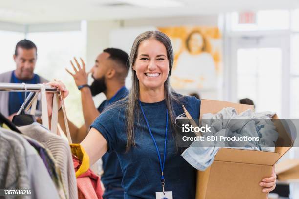 Mid Adult Female Clothing Drive Organizer Poses For Photo Stock Photo - Download Image Now