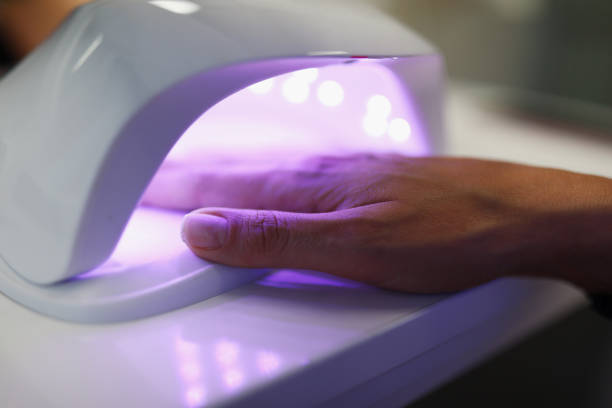 Self care and spa Close-up of woman putting hand under uv lamp. Gel nail polish. Fresh and beautiful manicure. Fashion and cosmetics. Beauty salon and beautician appointment concept cuticle photos stock pictures, royalty-free photos & images