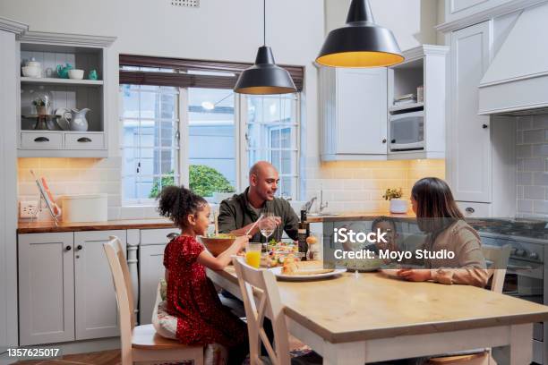 Shot Of A Young Family Enjoying A Meal Together Stock Photo - Download Image Now - Family, Dinner, Domestic Life