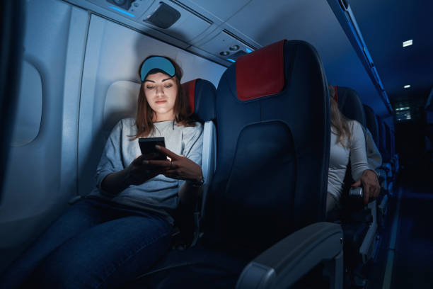 istock Female clicking her smartphone during night flight 1357625033